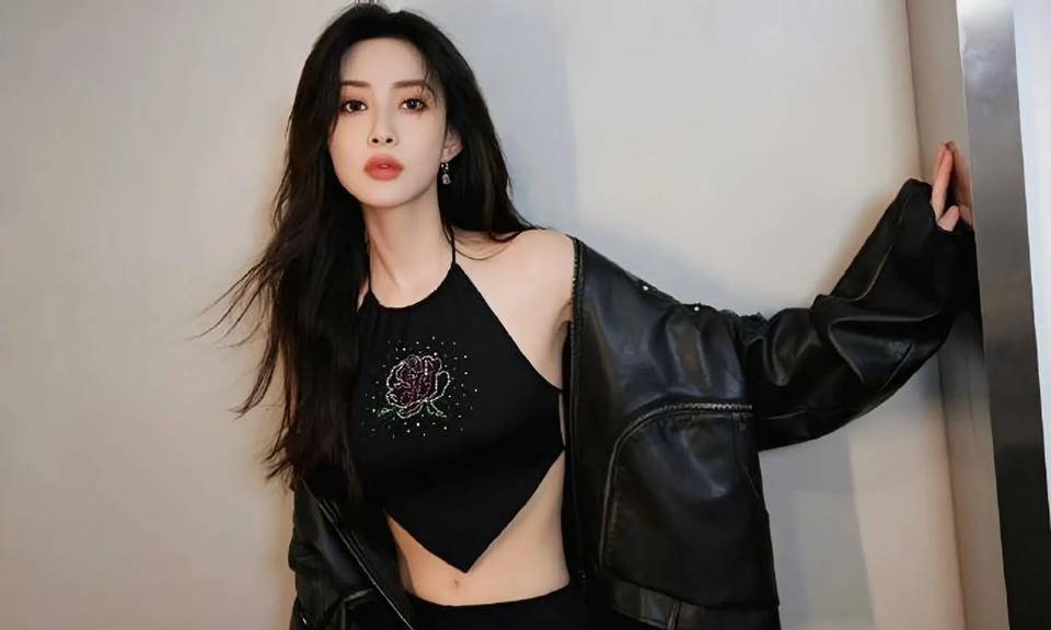孟子义一身黑色挂脖肚兜，缀闪亮玫瑰，搭配同色下装，又酷又辣。长发披肩，姿态随性，