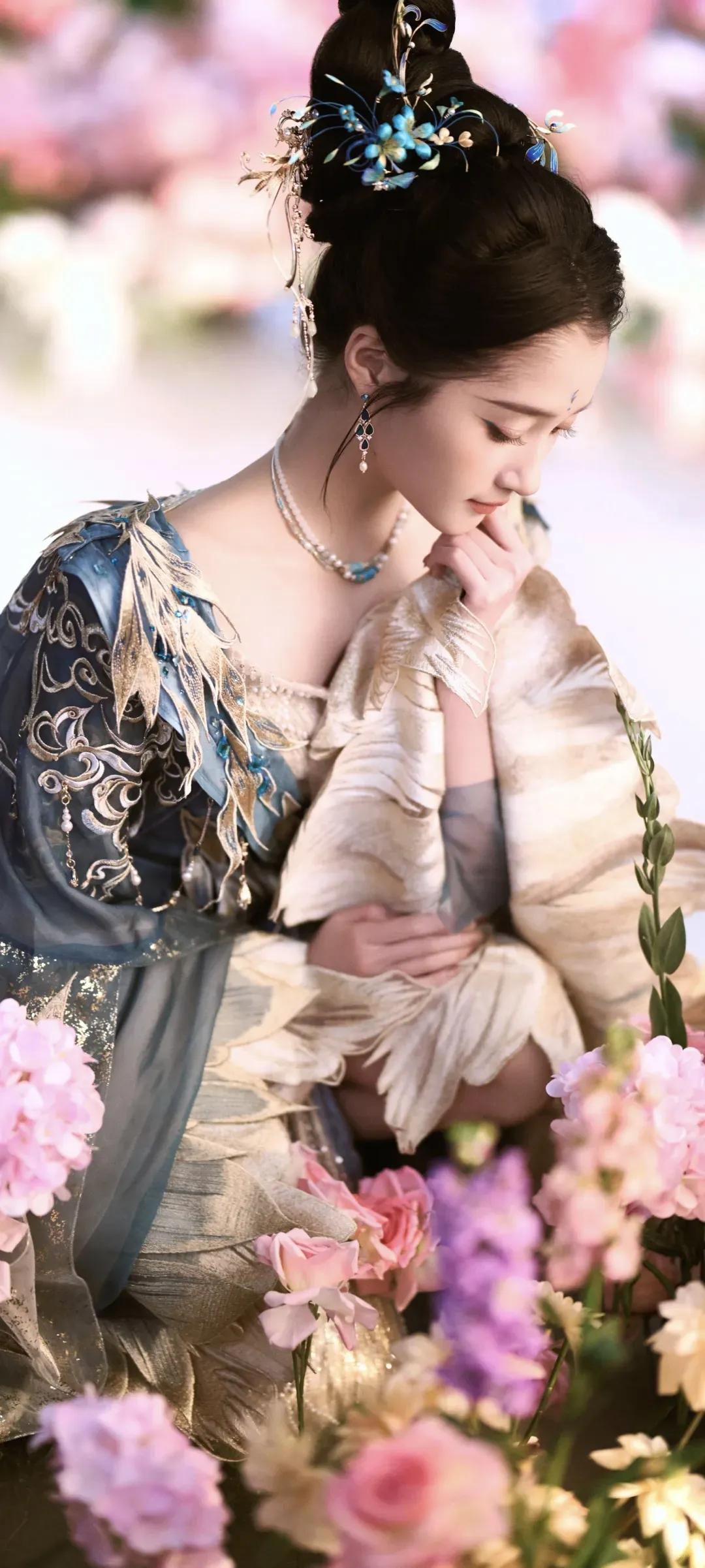 一袭蓝金交织的古风华服，绣满灵动羽纹，层叠纱幔如流云漫卷，关晓彤化身从古籍中走出