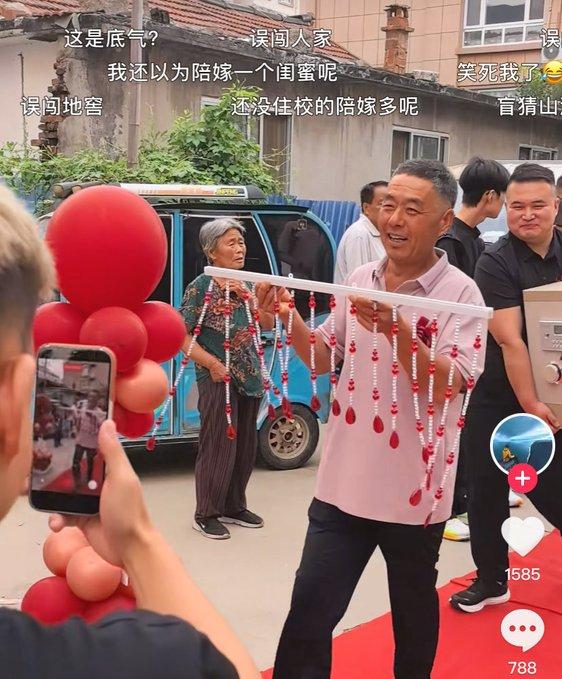 婚礼现场一幕引发不少讨论。姑娘手里捧着一块红色牌子，上面写着闺蜜送来的陪嫁：螺