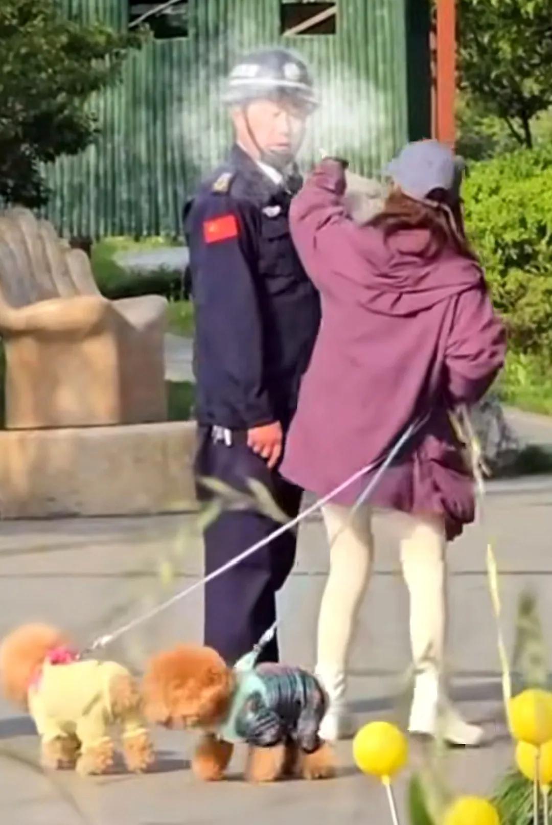 浙江嘉兴某公园。外地女子带两条狗游玩，未给狗子牵绳，保安发现后，提醒女子拴狗绳