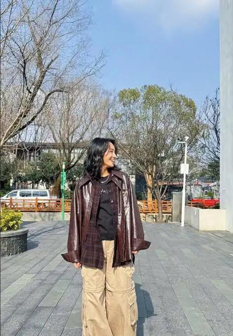 朱丹的穿搭模式，其中有衬衫、打底衫的叠穿，下装搭配的是工装裤，那种松弛感真的是格