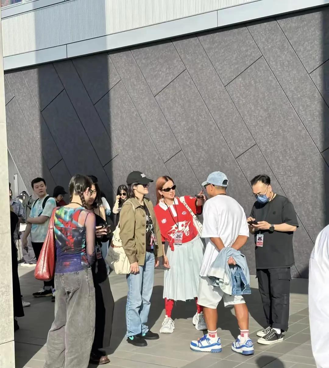 人群中徐濠萦的上红下白搭配非常抢眼，力压同框的其他合照者和路过的路人，成为焦点…