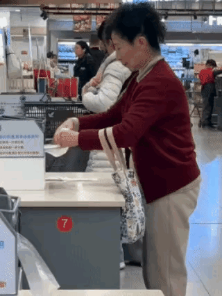 丢人现眼！大妈在超市狂扯塑料袋，让人咋舌。某超市一角，见一位穿红色毛衣大妈，