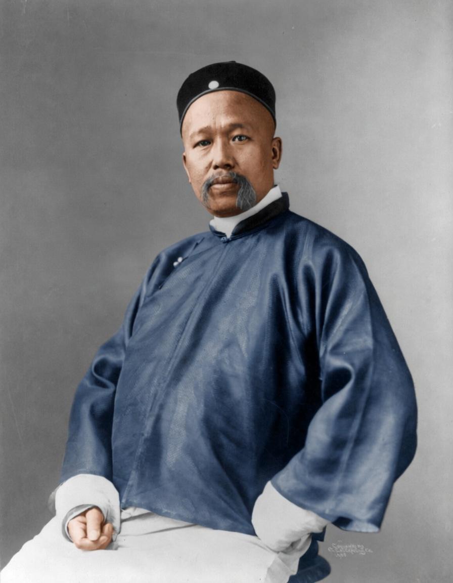 这张照片拍摄于1905年，是康有为47岁时的正式肖像照，他坐姿端正，神情严肃沉稳