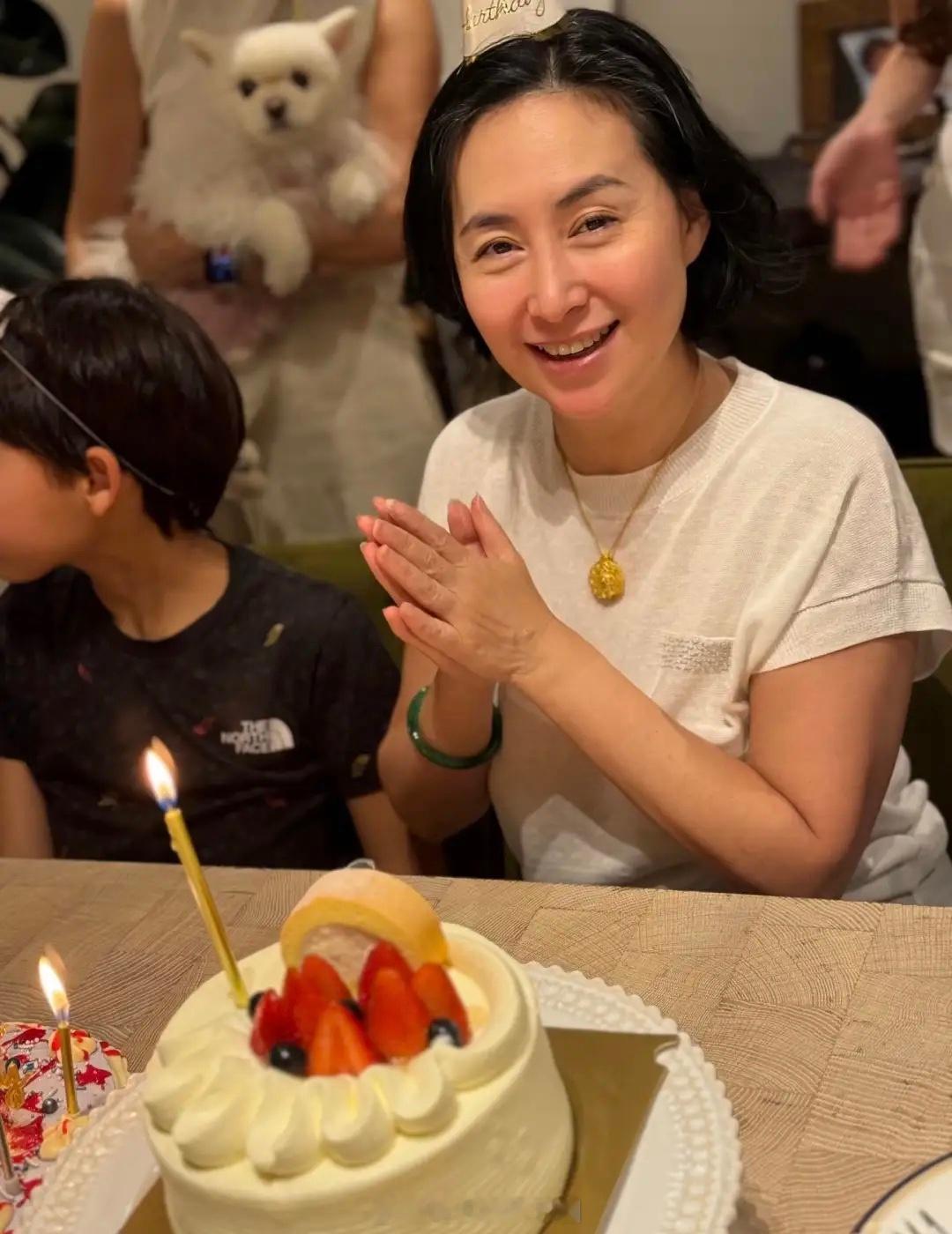 64岁何超琼和干女儿曾昭仪一家庆祝生日，她穿着一件简单的白色短袖上衣，脖子上戴着