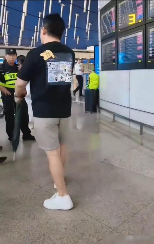 白海豚提前登陆，部分航班临时取消，一名手拿长把子伞的男子极为不满，在候机大厅情绪