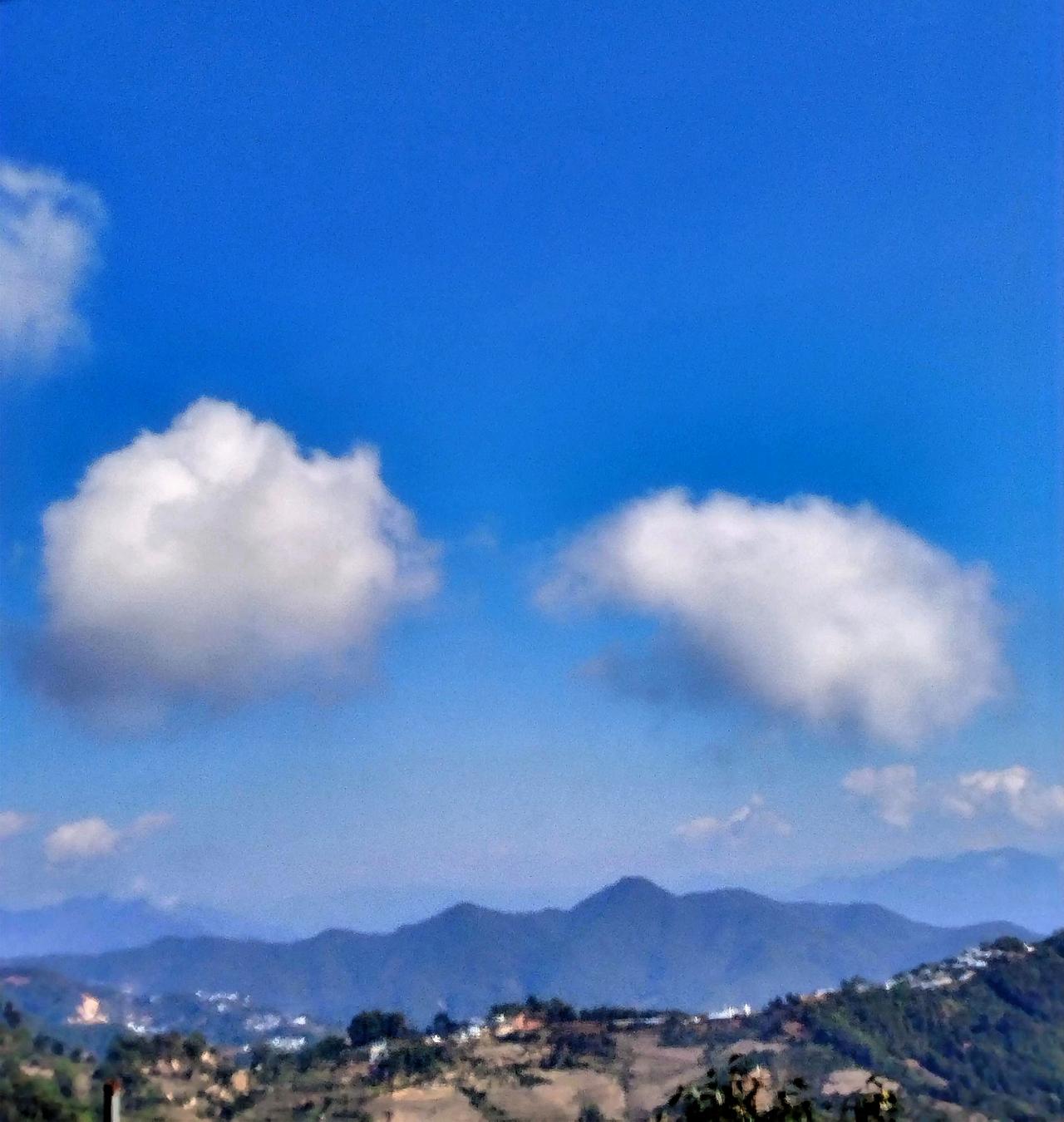 蓝天白云下的山峦，宁静而美丽。那连绵的山峦在蓝天白云的映衬下，仿佛一幅绝美的画卷