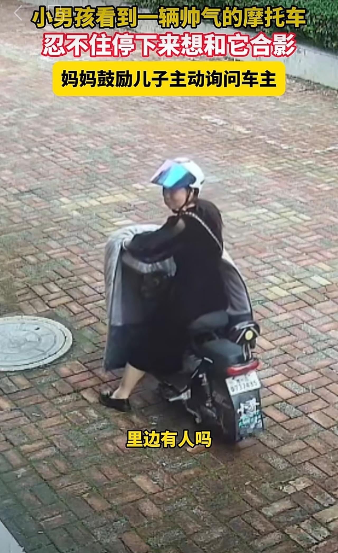 10月8日，山东青岛，小男孩看到一辆帅气的摩托车，忍不住停下来想和它合影，妈妈鼓