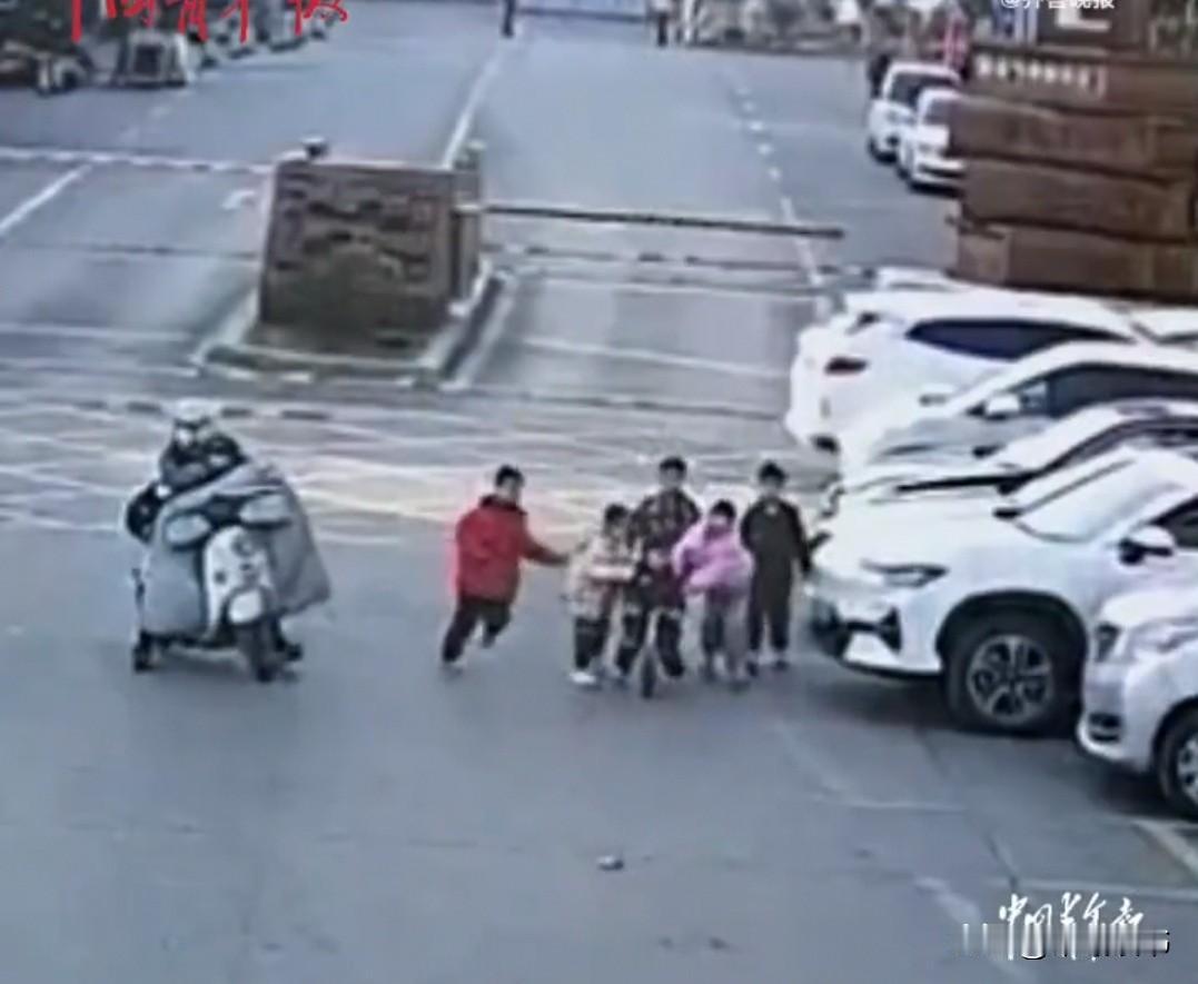 湖北襄阳街头，5名小学生正走着，忽然看见警车驶过，立刻拼命挥手。路人连忙劝阻：“