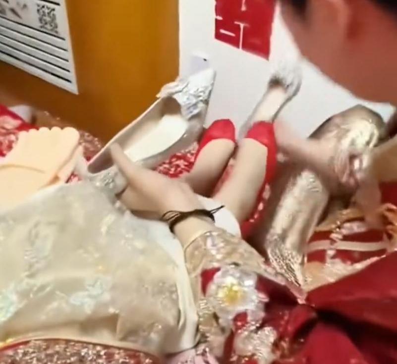 办喜事的新郎在自己接亲时，忙碌加紧张中没有看好手里鞋子的左右，直接为新娘把鞋子穿