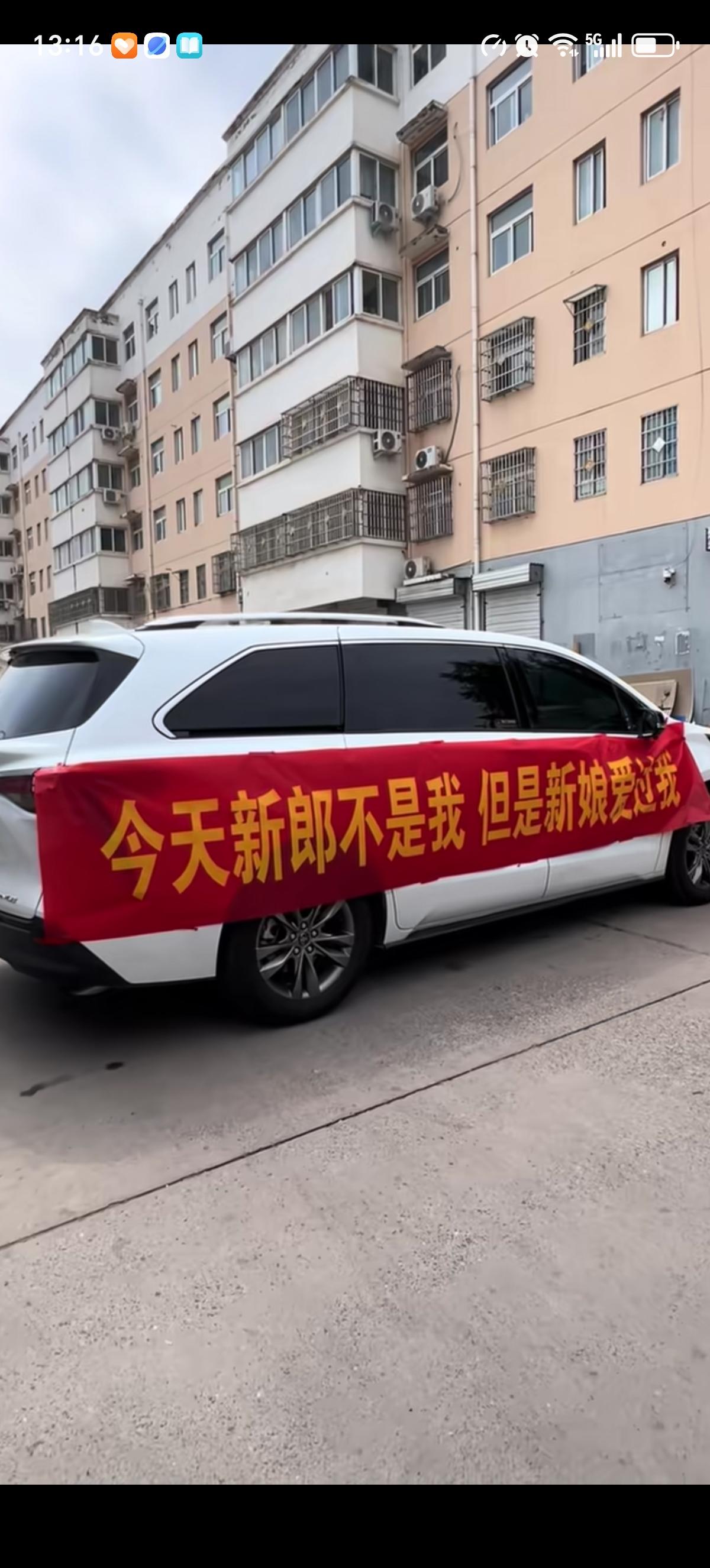 新娘今天出嫁，一辆白色轿车拉着横幅“今天新郎不是我，但是新娘爱过我”拦在在了新娘