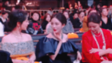 辛芷蕾看起来并不想给杨幂捧场，她双手环抱胸前，这是典型的对人防范和不想亲近的姿态