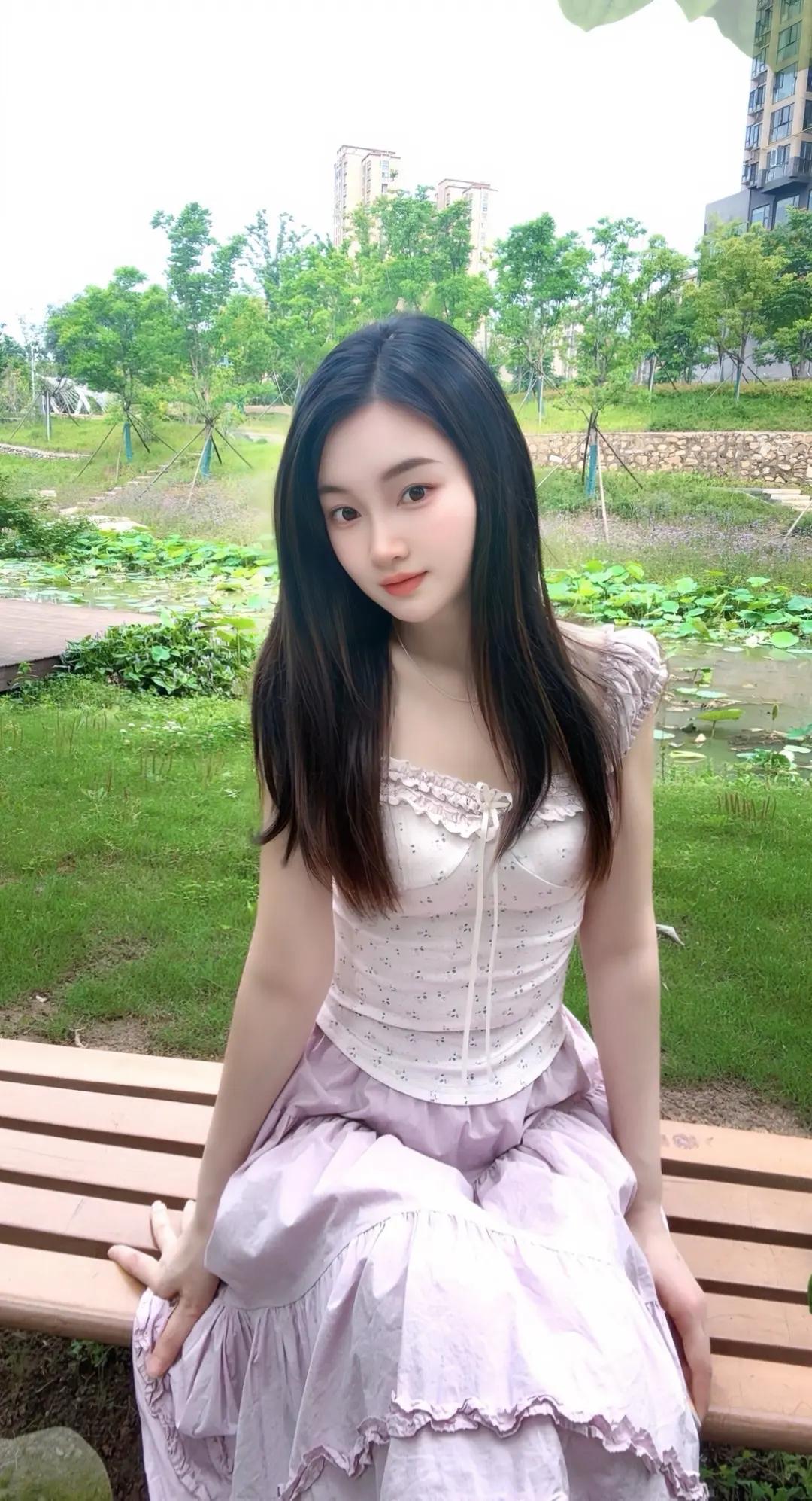 公园长椅上坐着一个漂亮姑娘。