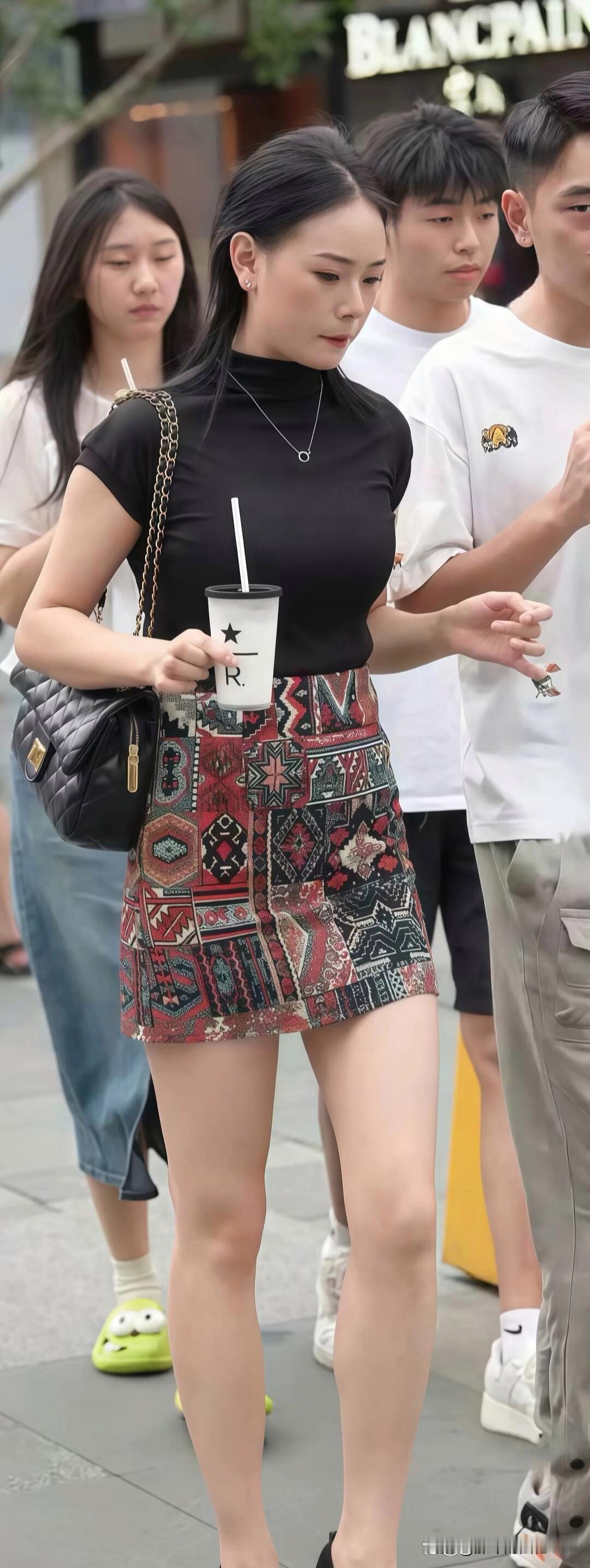 都市街头，想要时尚又舒适的穿搭，黑色上衣配印花短裙就超绝。黑色上衣经典百搭，像