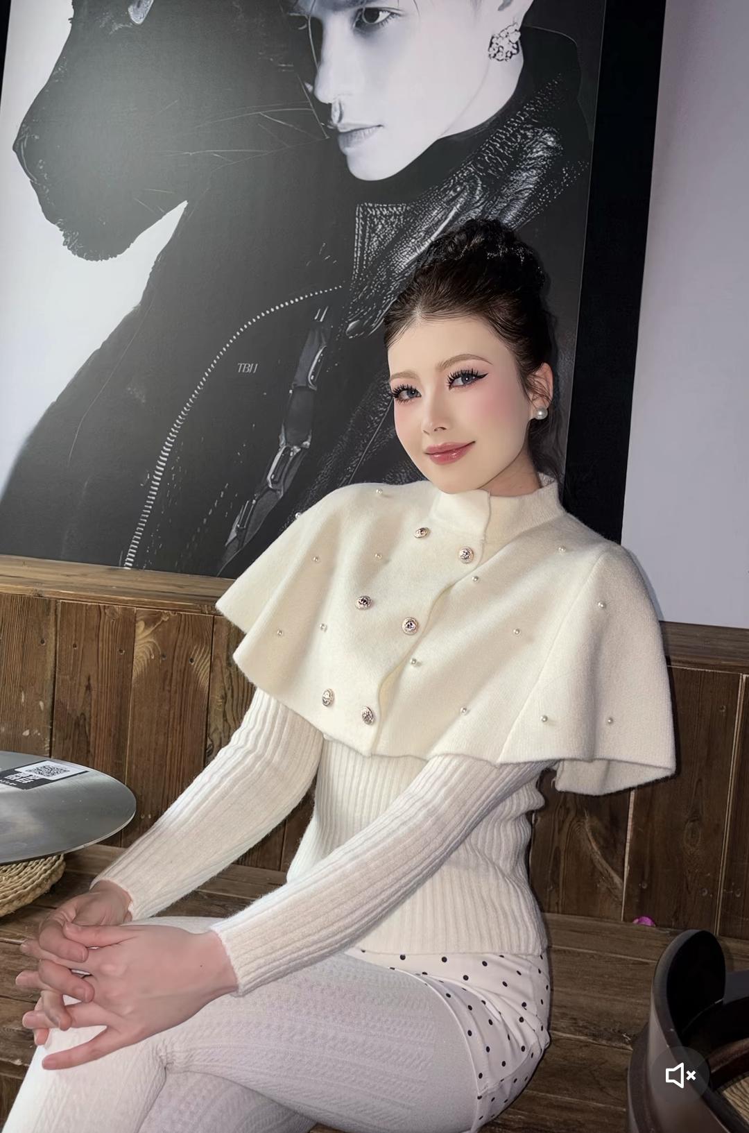 优雅白衣少女，坐在复古木桌旁，背景是酷炫的黑白画作，散发着时尚与艺术的气息。