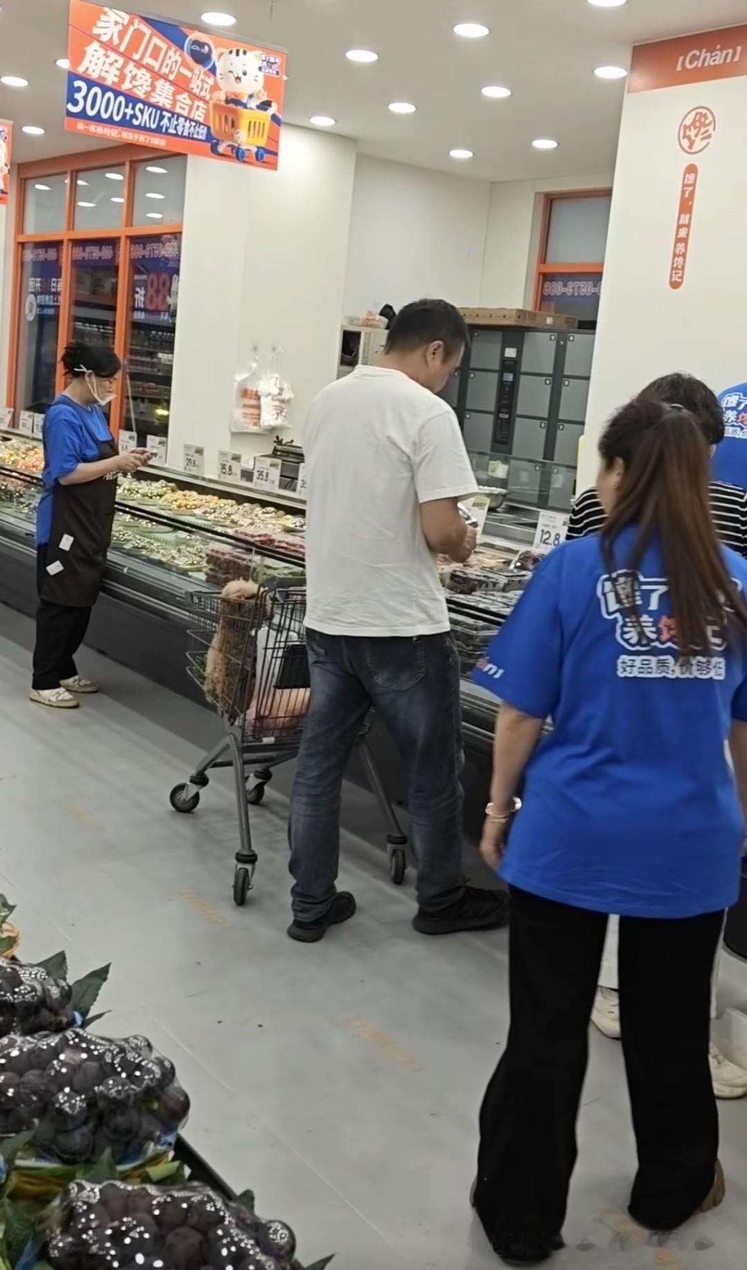 鲜切水果区，三名工作人员看到棕色泰迪犬在购物车筐里探头探脑，不仅没有任何制止，还