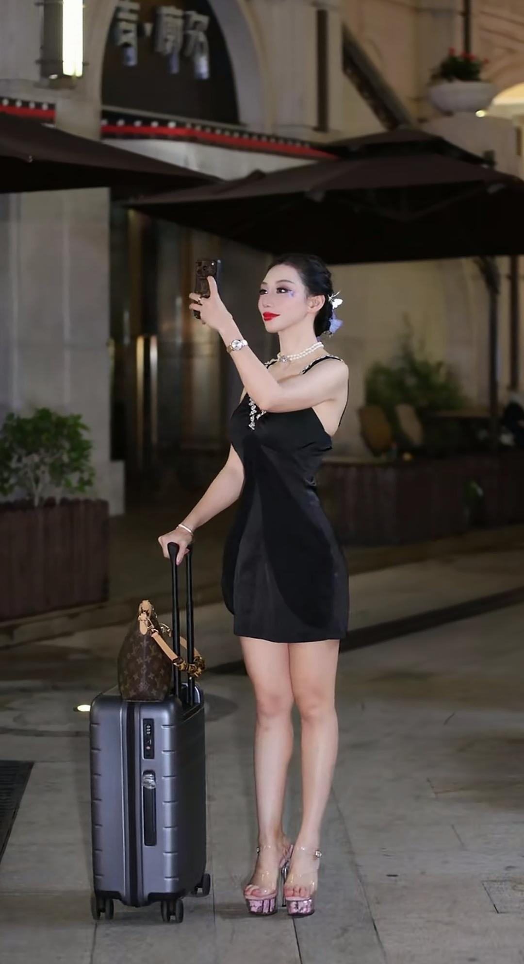 都市夜色下的时尚旅行者，优雅自拍，手提爱马仕，漫步在繁华街头。