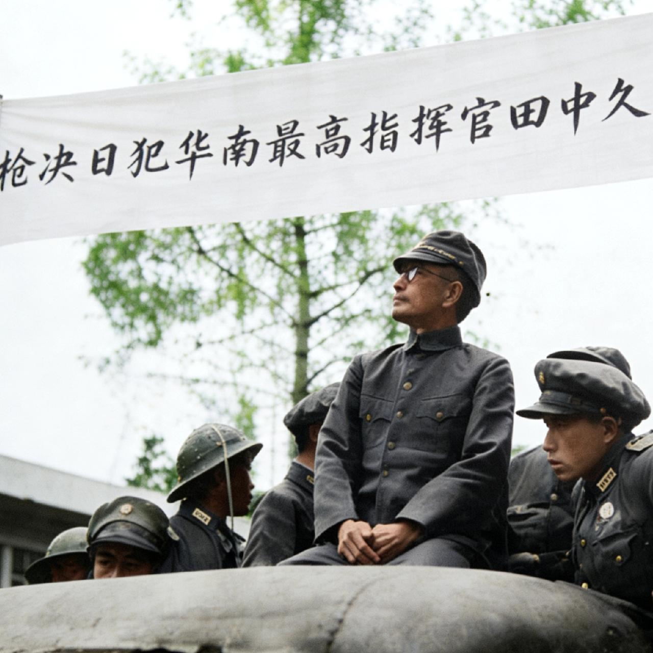 1947年，日本战犯田中久一，被押到敞篷卡车上游街示众时，留下的一张照片，镜头中