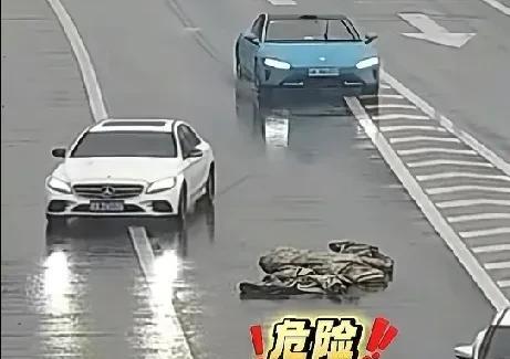 近日，南京机场高速，一大块黑色雨布横躺在高速公路匝道上，紧挨着应急车道口。此时，