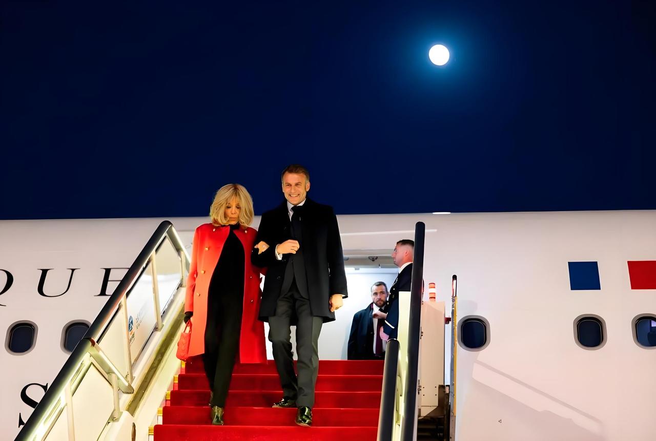 马克龙北京“红旗接驾”斗法太巧妙，妻子秀恩爱行李箱抢镜，专机不挂国旗背后藏玄机