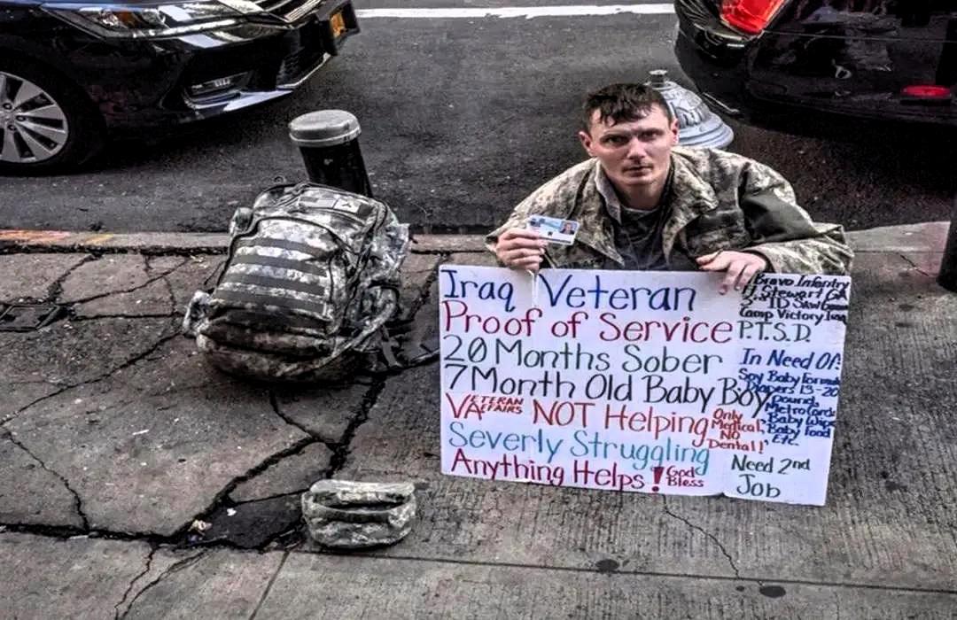 一位曾经在伊拉克战场上的退伍军人在美国的弗罗里达州街头乞讨，他手中的大牌子写到：
