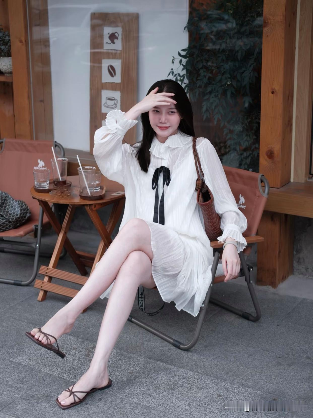 女孩子怎么穿搭既时尚又好看?优雅坐于花丛旁，白色连衣裙与自然和谐共存。