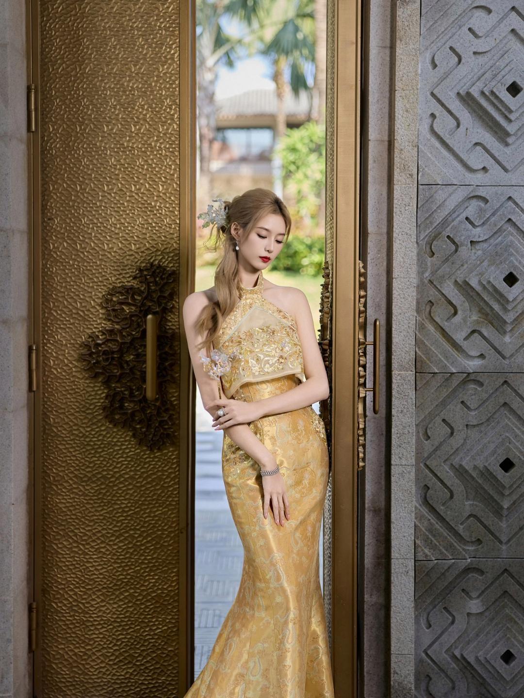 徐艺洋鎏金刺绣挂脖长裙自带贵气感，镂空露背+拖尾设计又添了丝灵动；搭配同色系油纸