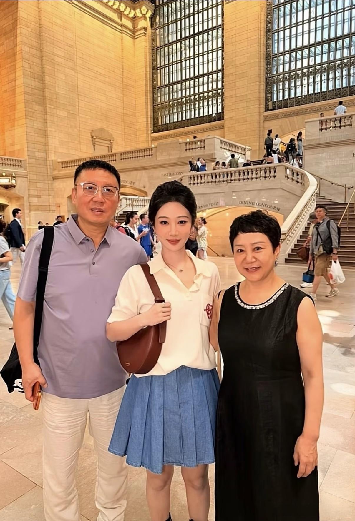 杨紫爸爸妈妈陪同女儿去纽约工作，一家三口在中央车站合影，妈妈穿黑色连衣裙优雅