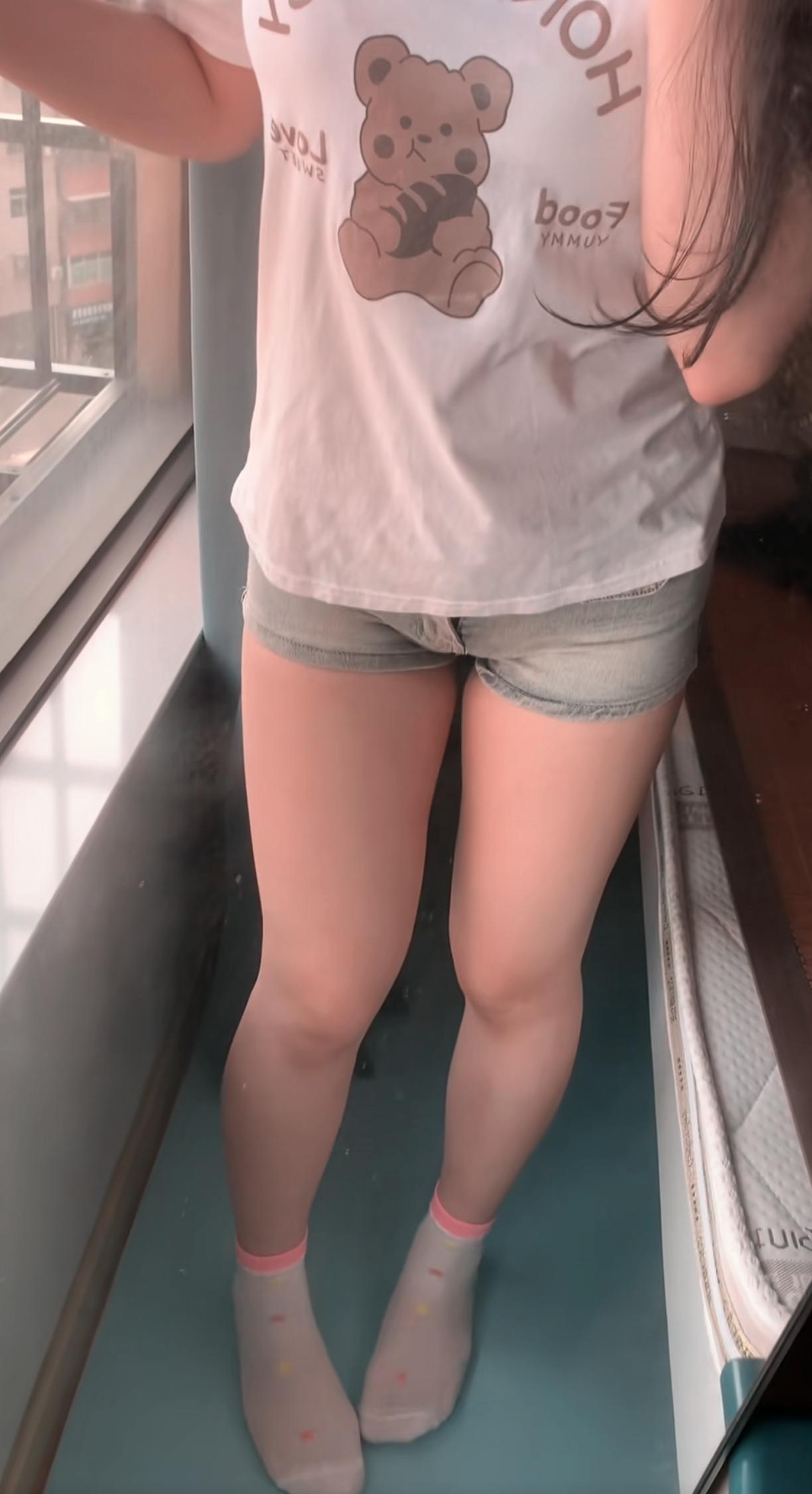 不穿鞋在阳台休闲的邻家女孩。