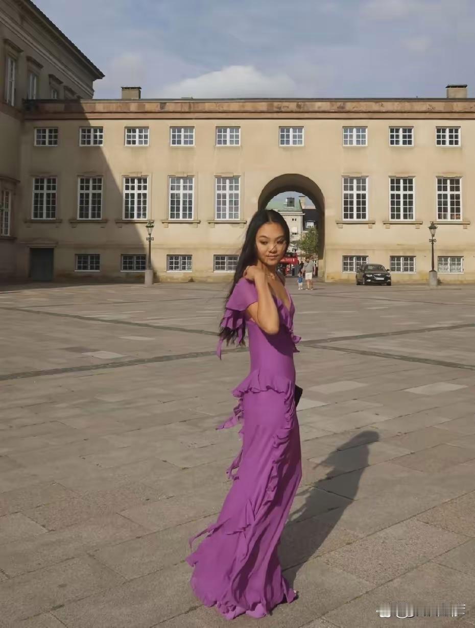 李连杰大女儿远赴丹麦参加友人婚礼晒礼服照引来热议，她挑了心仪紫色礼裙出镜，身段火辣高挑，脸蛋底子普通
