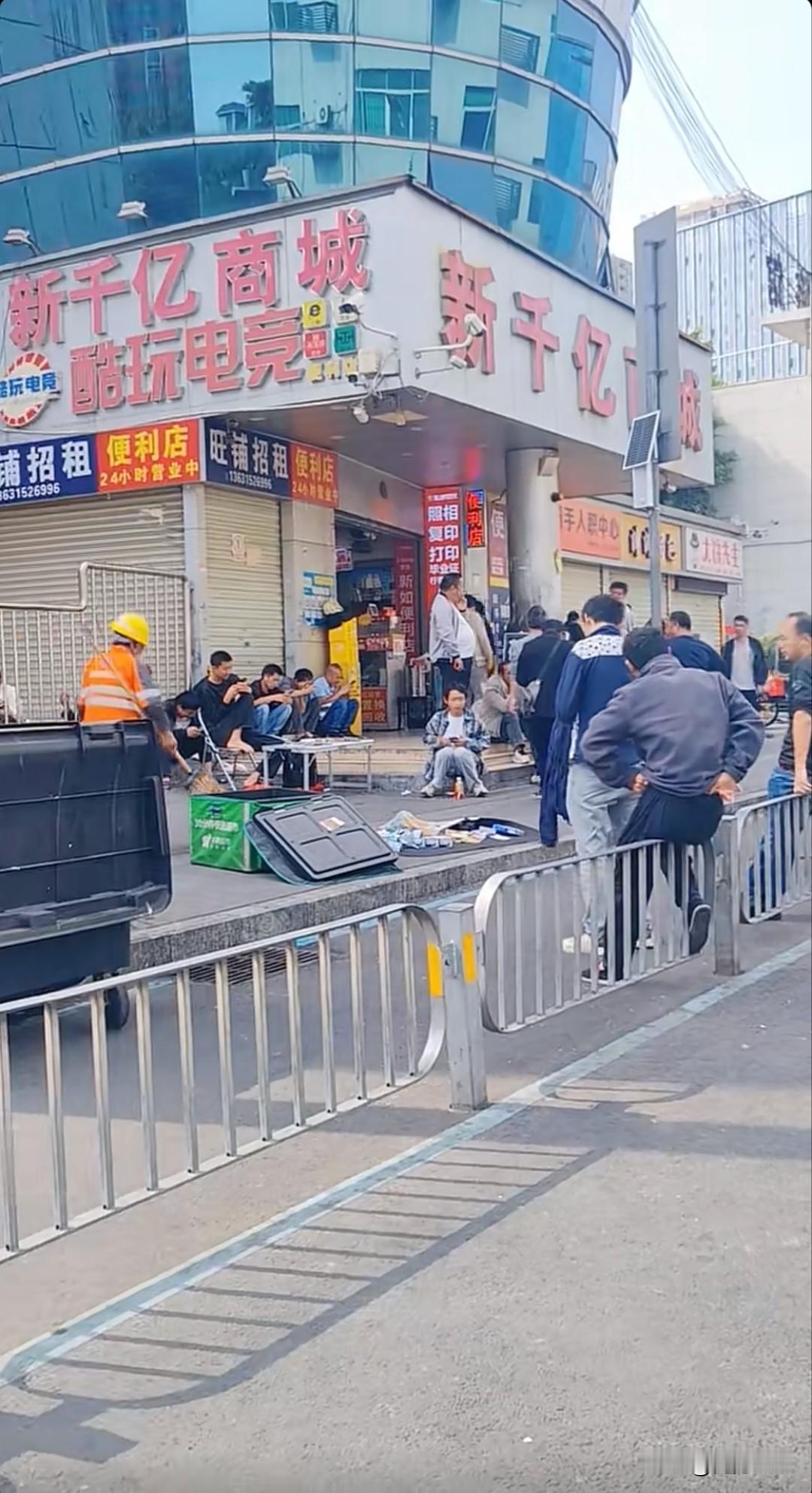 初六的深圳龙华汽车站，人潮汹涌。新千亿商城门口，黑压压围了一大群老哥，有的蹲着刷