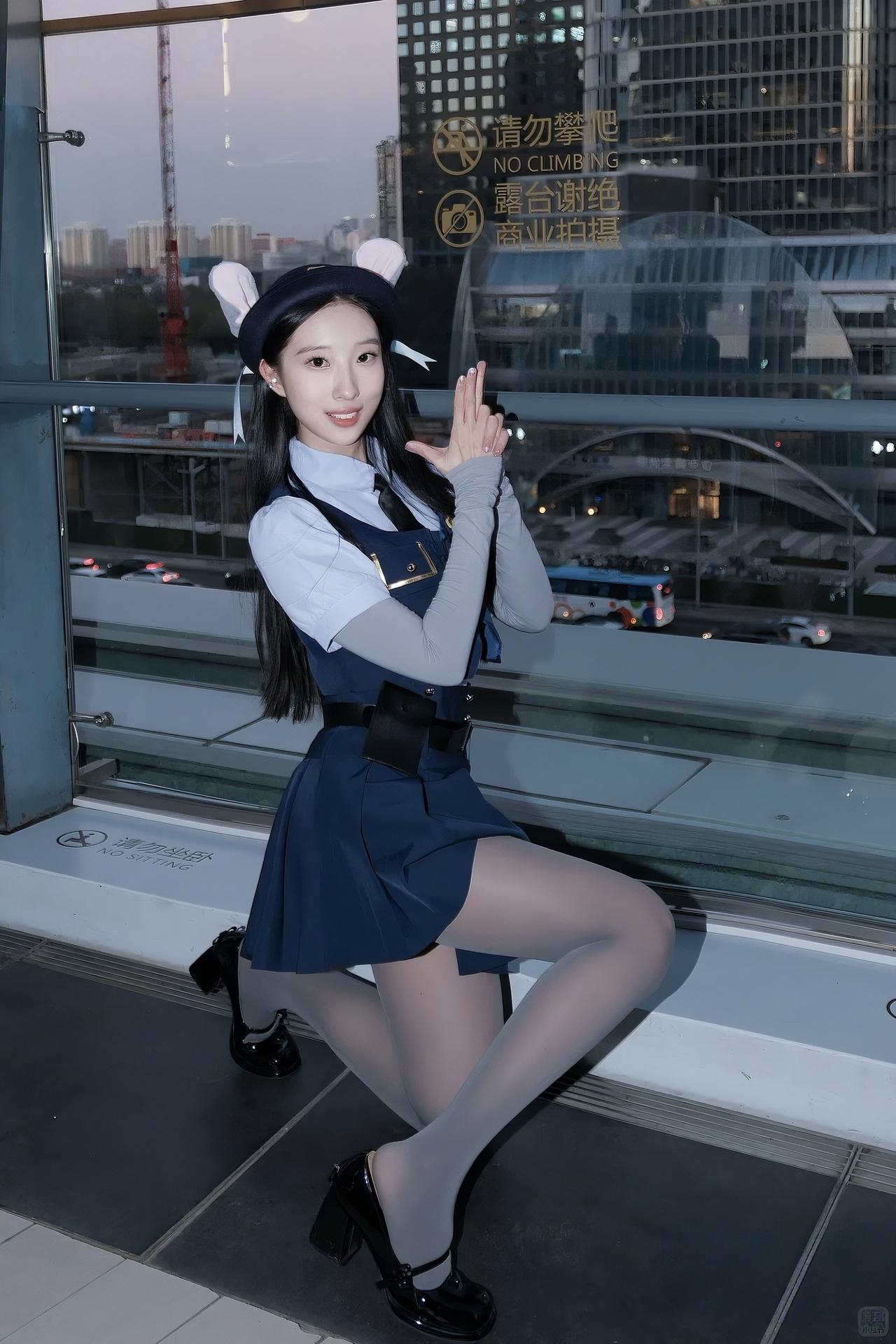 在央视大楼旁的露台邂逅暮色🌆一身蓝调制服搭配兔耳装饰，甜酷感直接拉满～百褶裙
