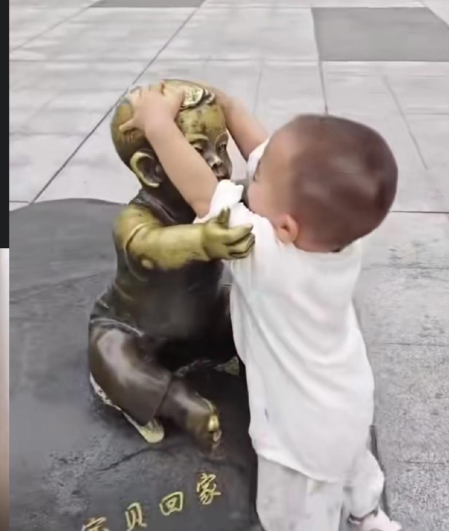 泪目！一位小男孩看到广场上的母子雕像，母亲张开双臂拥抱宝宝，宝宝也张开胳膊让妈妈