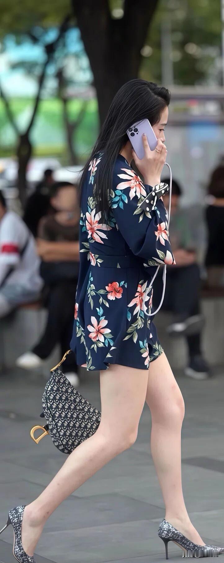 一位穿花裙子的女士在打电话。