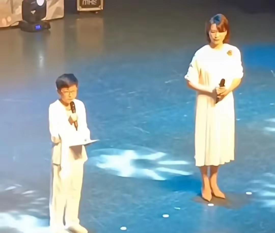 董卿终于又登台了，她拿起话筒好催泪，旁边的儿子清秀帅气……很难得，看到董卿再一