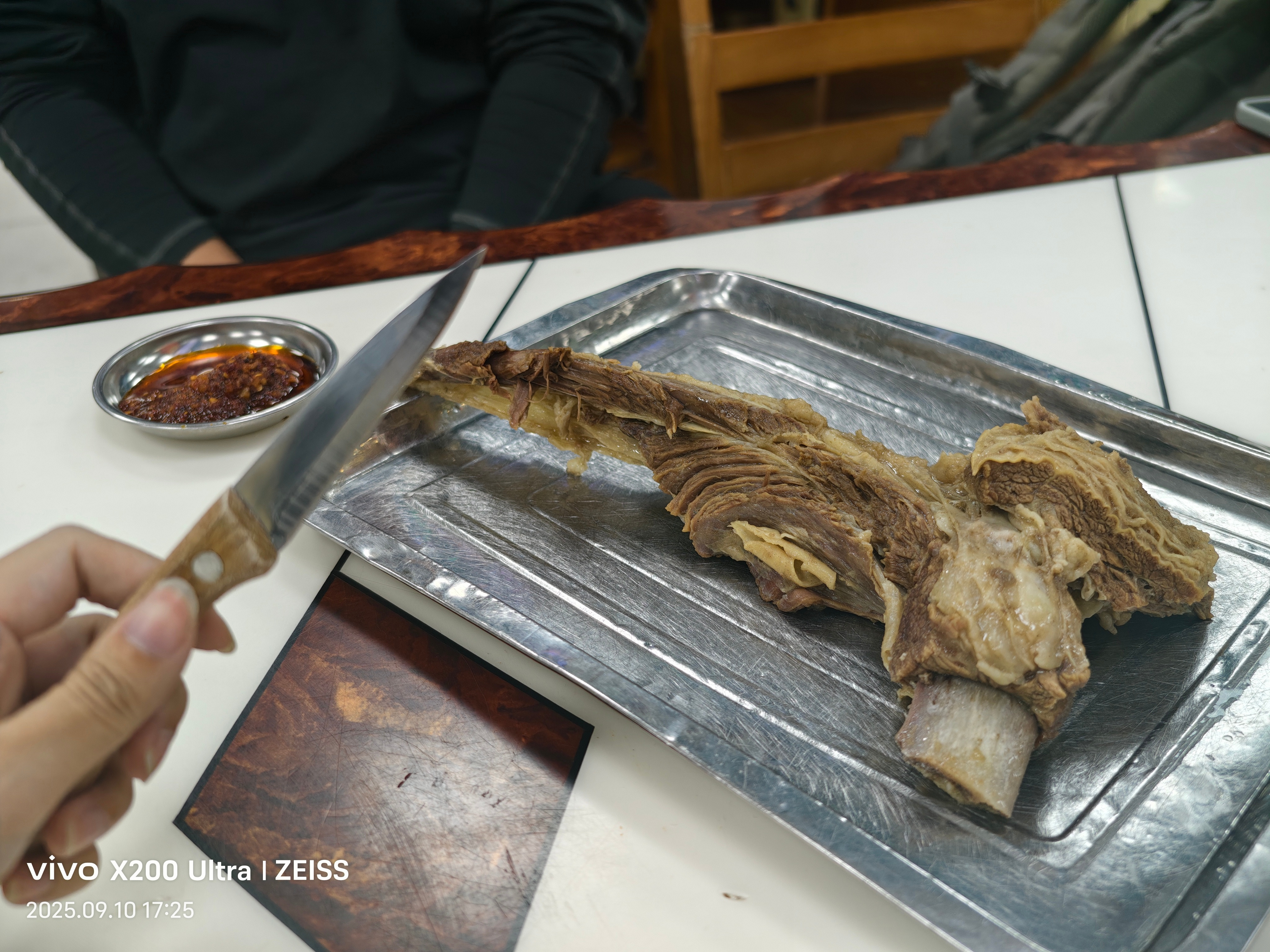 出差路过西宁，尝了尝当地有名的退骨肉。自己从肉堆里挑一块，给把刀一碟蘸料，你就吃