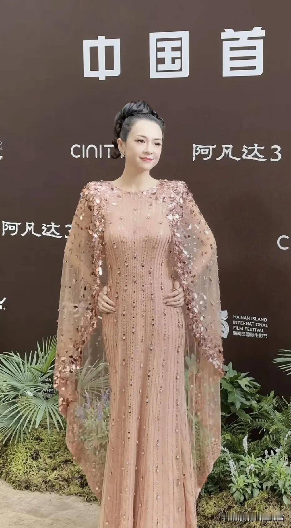 章子怡的最新亮相。肉粉色的长裙，很显年轻，很显嫩，点缀着数不清的亮片钻钻，闪