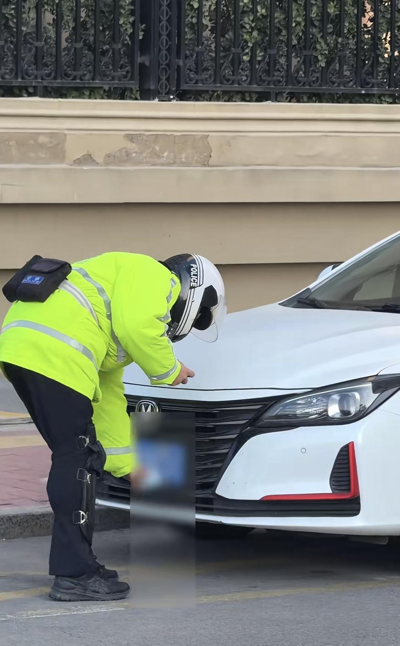 网友在街上拍到很多违停的车，这些车的车牌都被人戴上了口罩。这也导致交警过去处理的