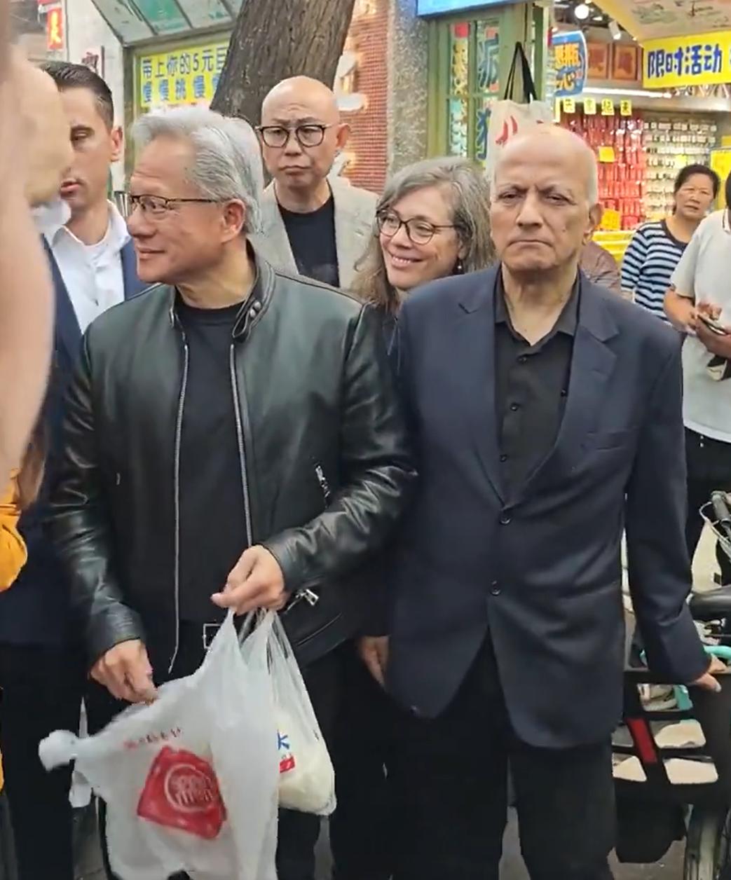 黄仁勋这个动作可不合适啊，怎么能随地乱扔塑料袋呢。仔细看，黄仁勋手上拿的这个