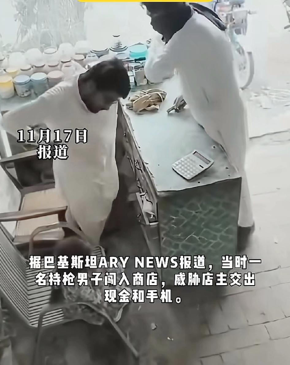 持枪男子闯进店里，威胁店主交出手机和现金，小女孩向劫匪伸出手递上手中的棒棒糖劫