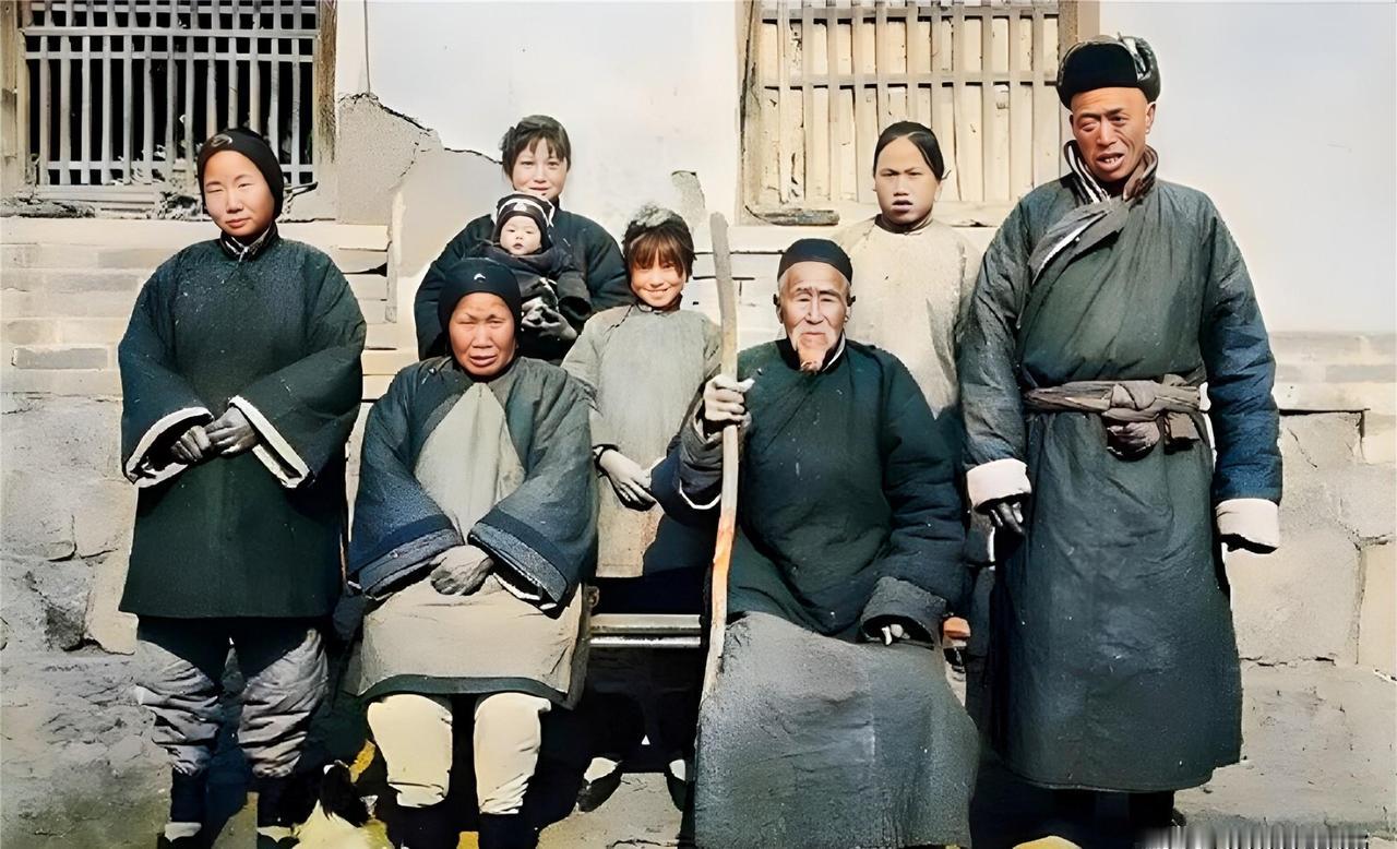 民国，一户小地主家庭拍全家福。照片里坐在中间的老爷子拄着根木棍，旁边的老太太