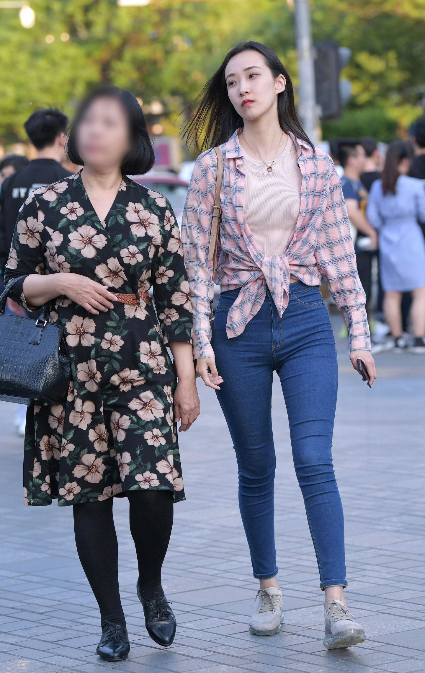 粉白格纹衬衫松垮地系在腰间，高腰蓝色紧身牛仔裤紧紧贴合腿部线条，将比例拉得恰到好