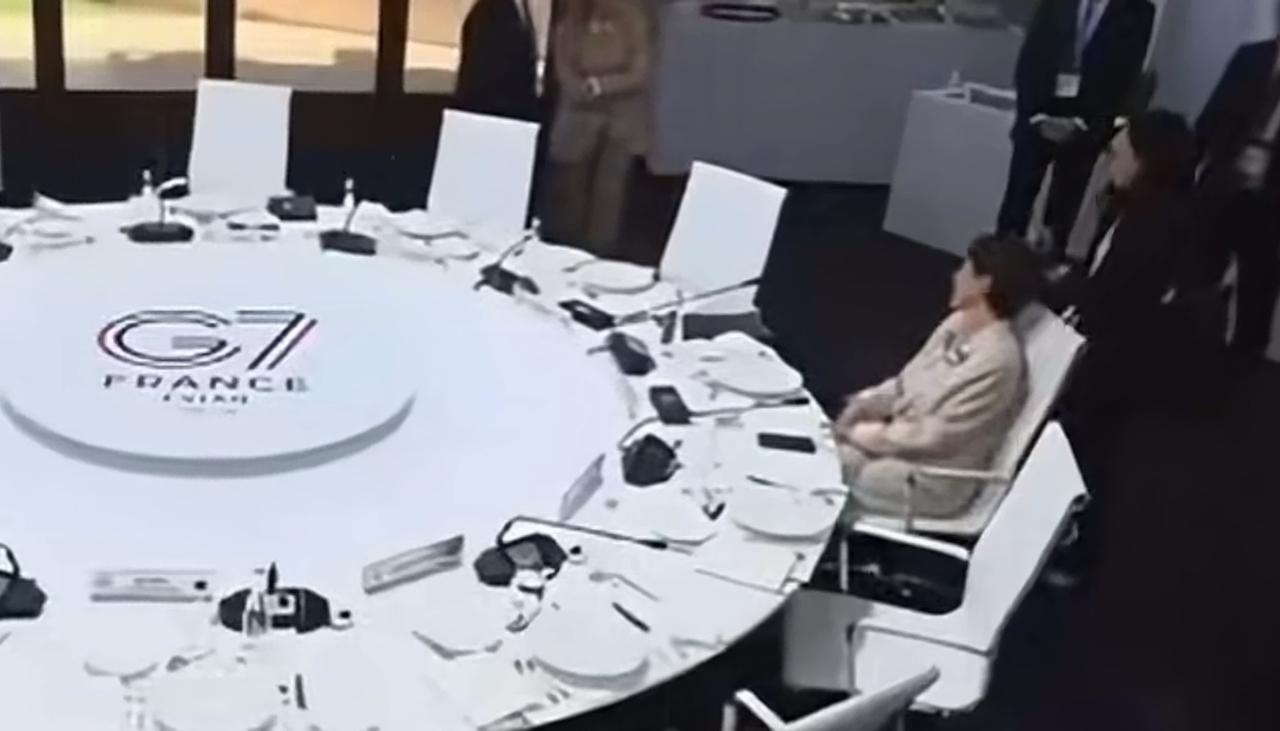 G7峰会上更尴尬的一幕——只有高士早苗坐在餐桌旁，转着椅子，瞅着别人在小范围交谈