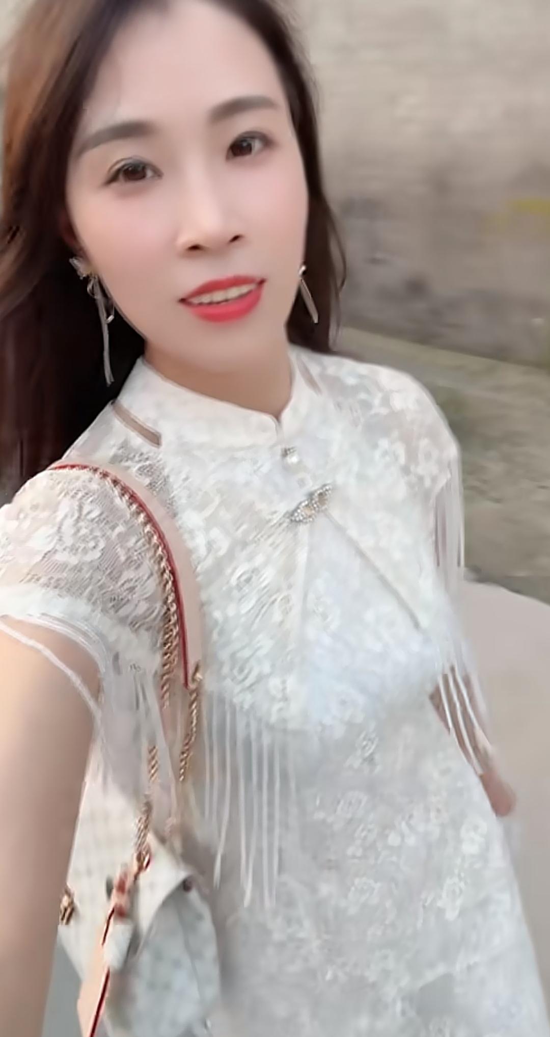 这位小姐姐穿着漂亮的白色连衣裙，美美哒！