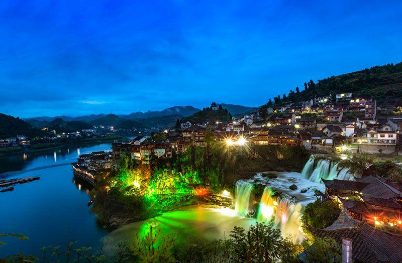 芙蓉镇的夜晚，是一场自然奇观与人文光影的梦幻交响。这座“挂在瀑布上的千年古镇”，