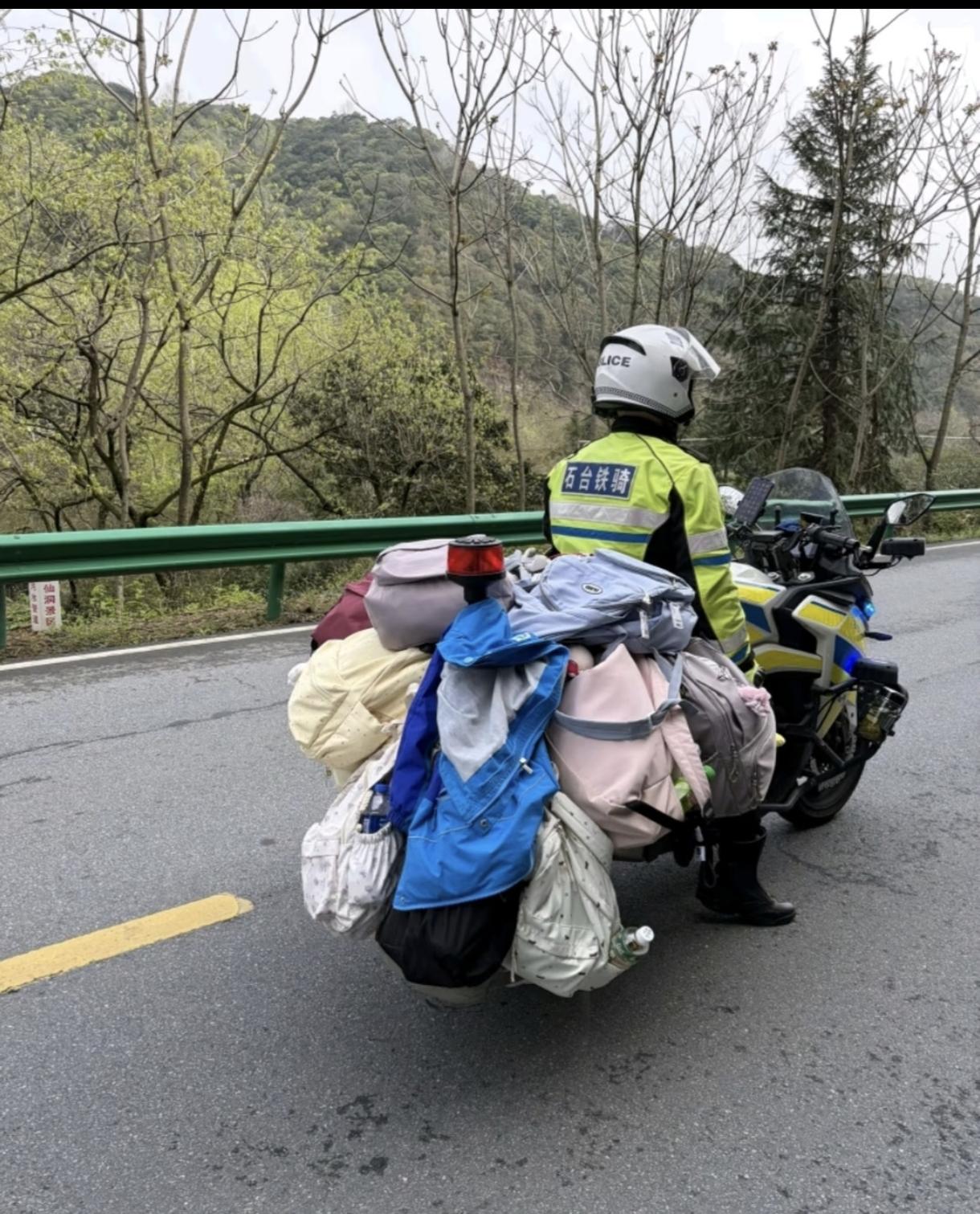 这交警也是位父亲，好可爱！咋一看还以为是环保志愿者的收拾路上的垃圾。人民警察为人