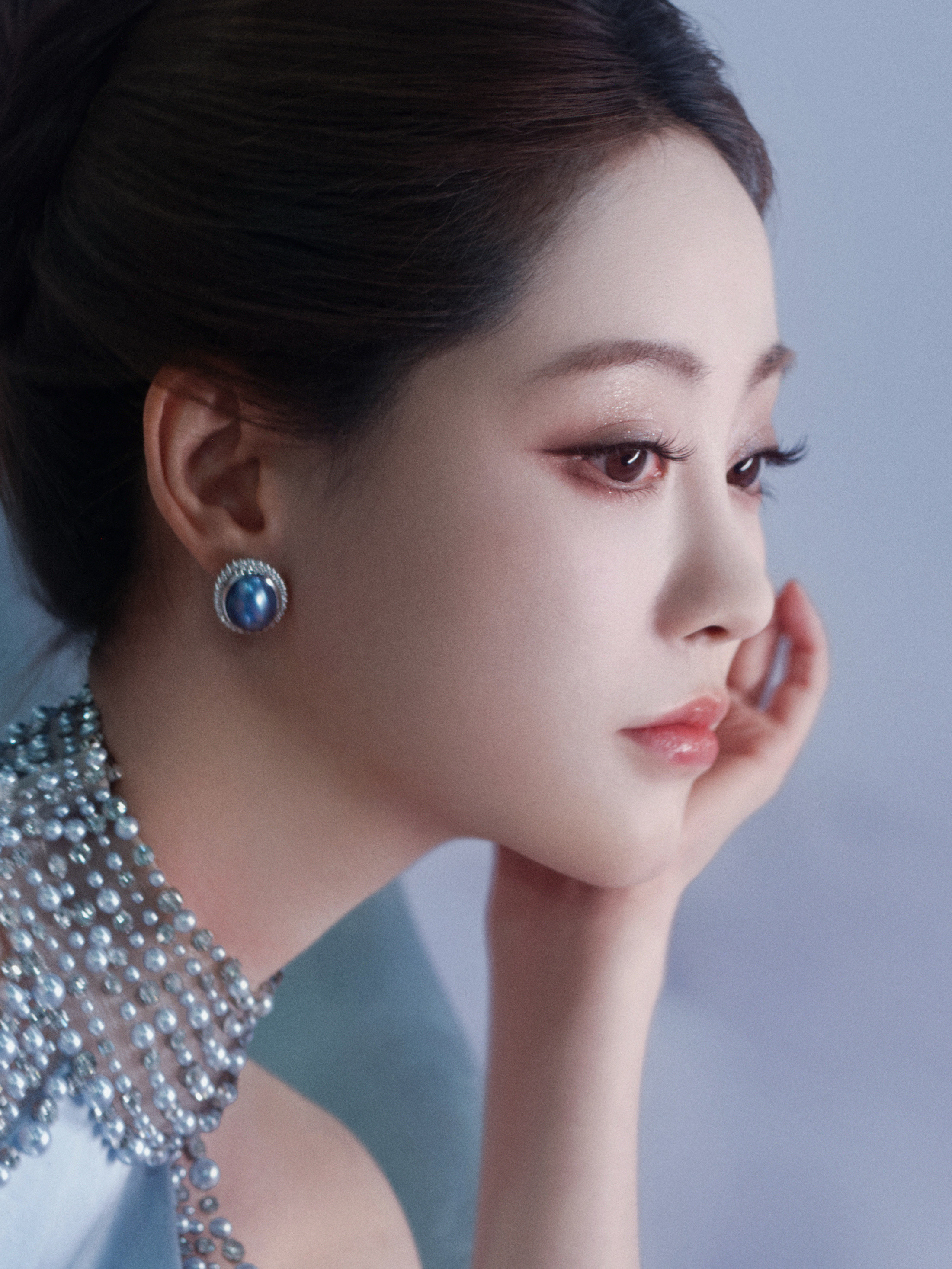 祝绪丹似坠入梦幻织物中的缪斯，冰蓝礼裙衬得肌肤胜雪，在柔紫与清蓝的褶皱间，以慵