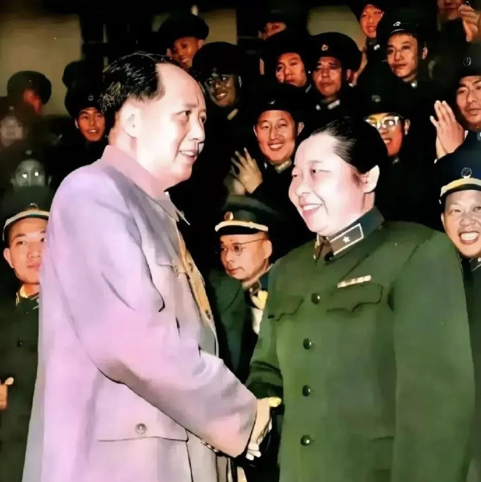 画面中，伟人身着朴素的服装，面带亲切笑容，与首位女将军李贞握手致意。李贞身着笔挺