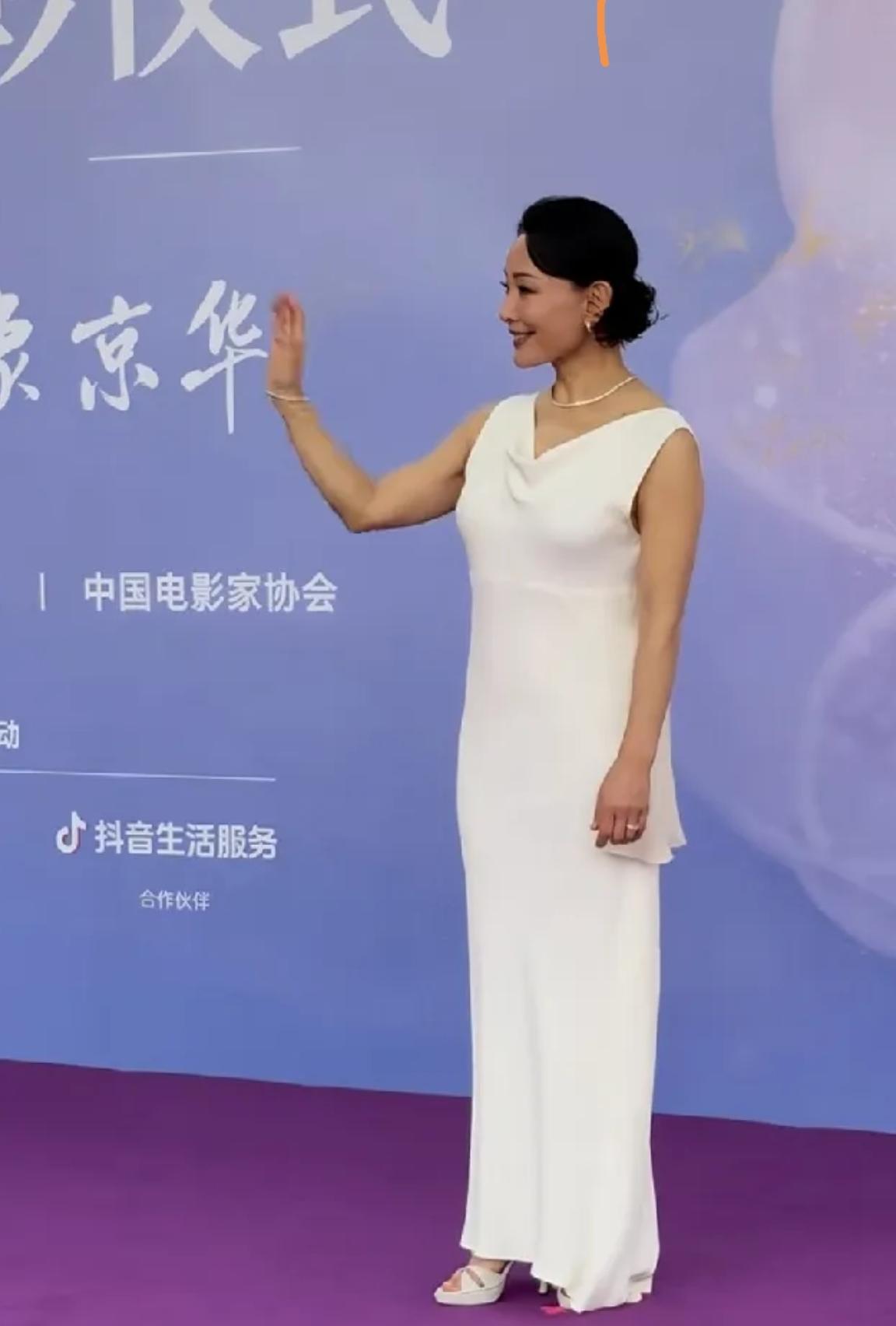 优雅大气！陈冲亮相百花奖现场[赞]复古的发型，一袭白色的露背长裙，白色的凉鞋，