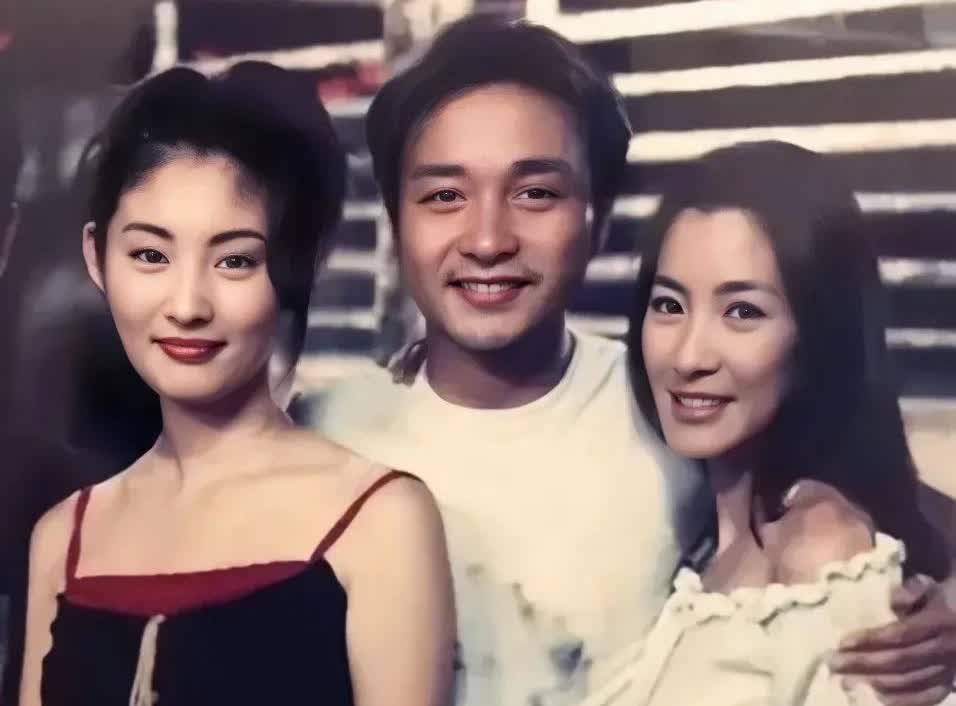 一张老照片，拍摄于1999年的香港，中间英俊帅气的男士是张国荣，右边美丽动人的女